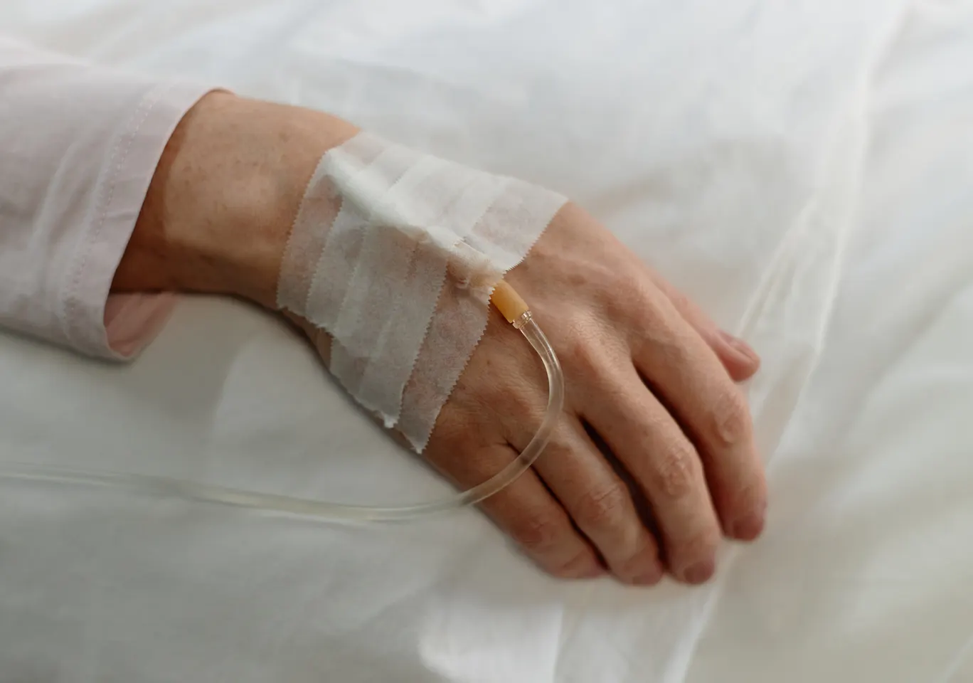 Kroplówki witaminowe Elbląg: dłoń z podłączoną kroplówką w spokojnym kadrze